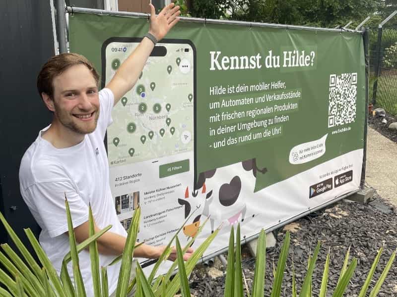 Gründer Michael vor einem Werbeplakat über FindHilde